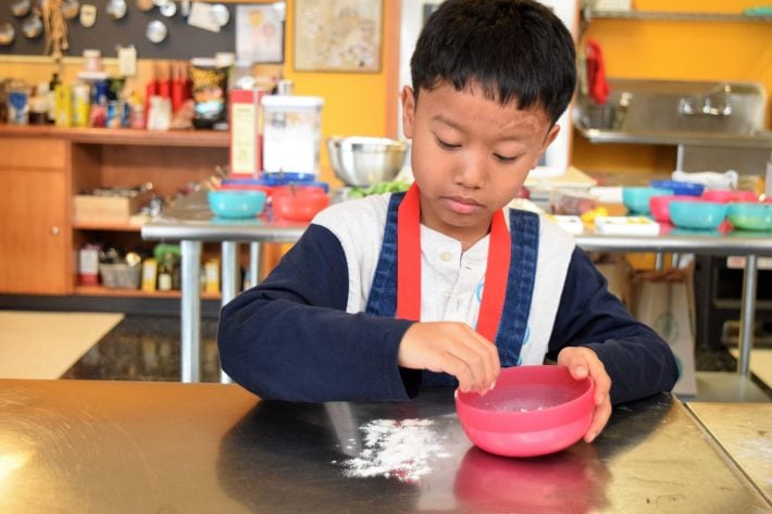 Child baking pies at the museum kitchen.