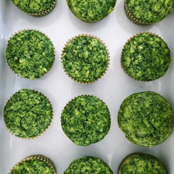 Fresh green spring muffins topped with herbs, perfect for a seasonal treat.