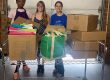 Three women donating backpacks for school supply drive at Miriam P. Brenner Children's Museum.