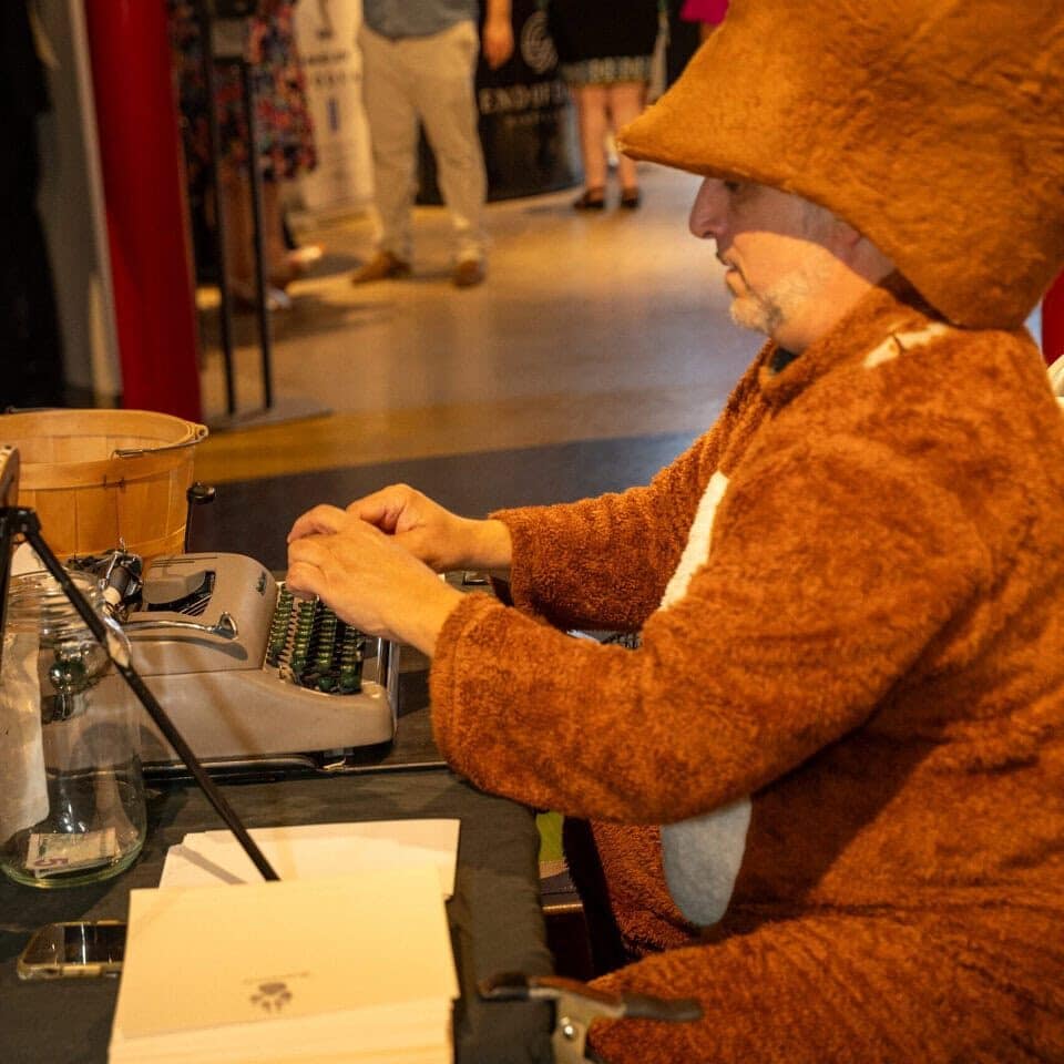 Person in fox costume working at a reception desk during the gala event.